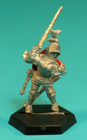 Pose 1. This is the foot figure, wearing full plate armour under his surcoat, and a full-face great helm with a hinged visor and a tall plume. A light mace and a scabbard hang from his belt, and he wields a broad-bladed two-handed sword.