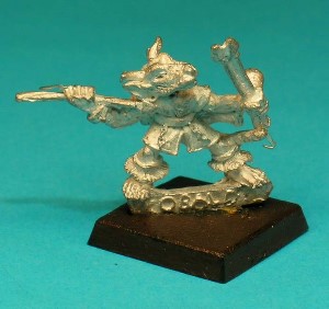 Pose 3, variant C. This figure holds 2 javelins in his left hand, and is about to launch a third one with his right. He is bare-headed, with 2 long, pointed horns, large ears and a scar on his right cheek. He has a closed mouth.